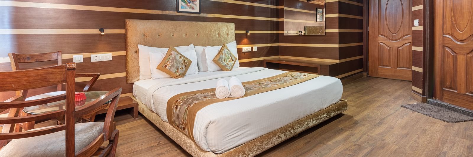 Super Deluxe Room with a king size bed and wooden finished flooring at DLS Hotels The Rock Castle.